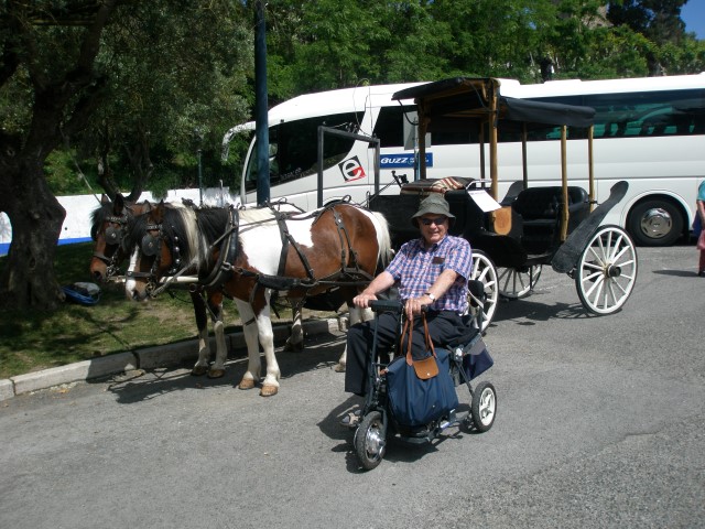 Customer riding our Di Blasi mobility scooter (located next to a horse and buggy.)