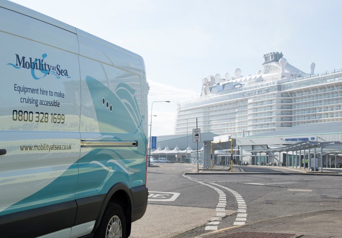 A Mobility at Sea van with a cruise ship docked in the distance