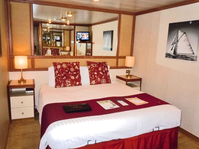 A double bed in a cabin on a cruise ship