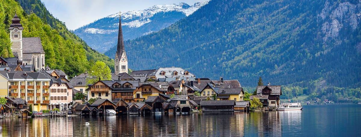 Scenic village with a church steeple, surrounded by fjord, mountains and forests.